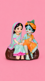 Handcrafted 9cm mini multi-colored radha krishna statue for gift purposes held in hand . Mini Radha Krishna Statue for Gift
